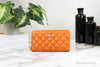 versace dark orange quilted clutch wallet on marble table