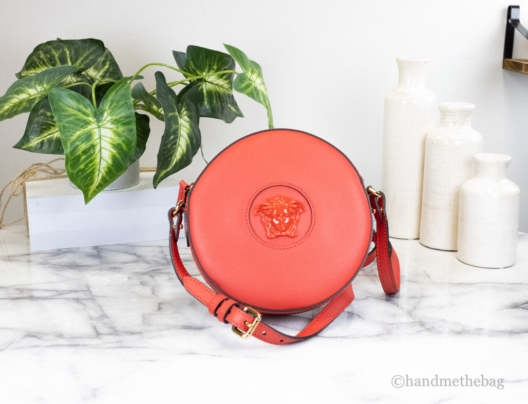 versace disco round red crossbody on marble table