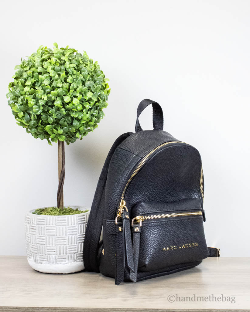 marc jacobs mini black backpack on wooden table