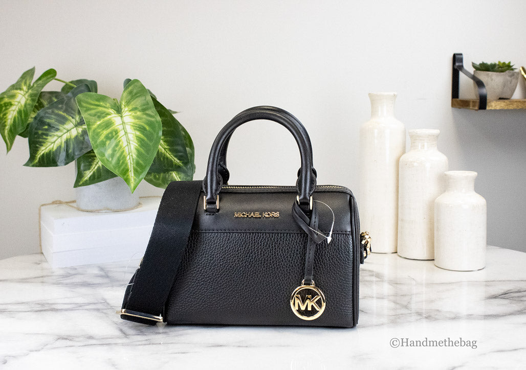 michael kors travel xs black duffle crossbody on marble table
