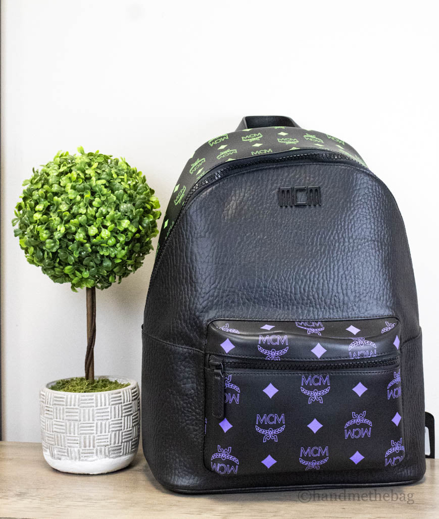 mcm color splash green purple backpack on wood table