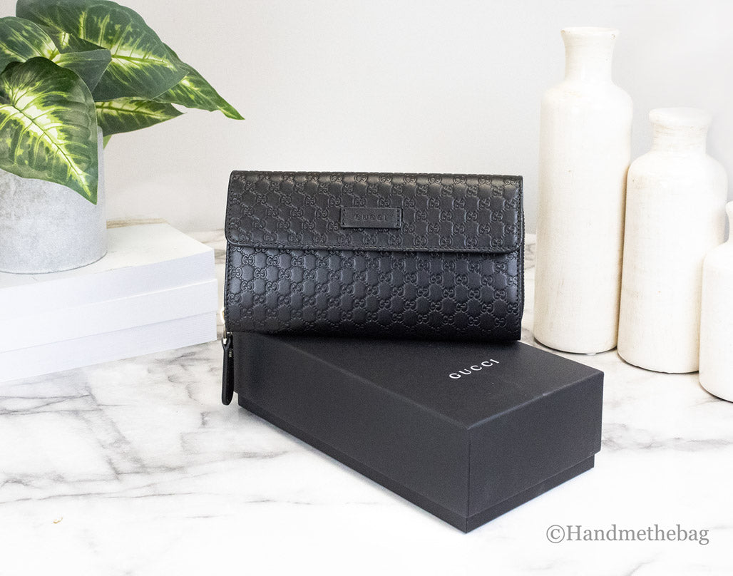 gucci microguccissima black clutch wallet on marble table