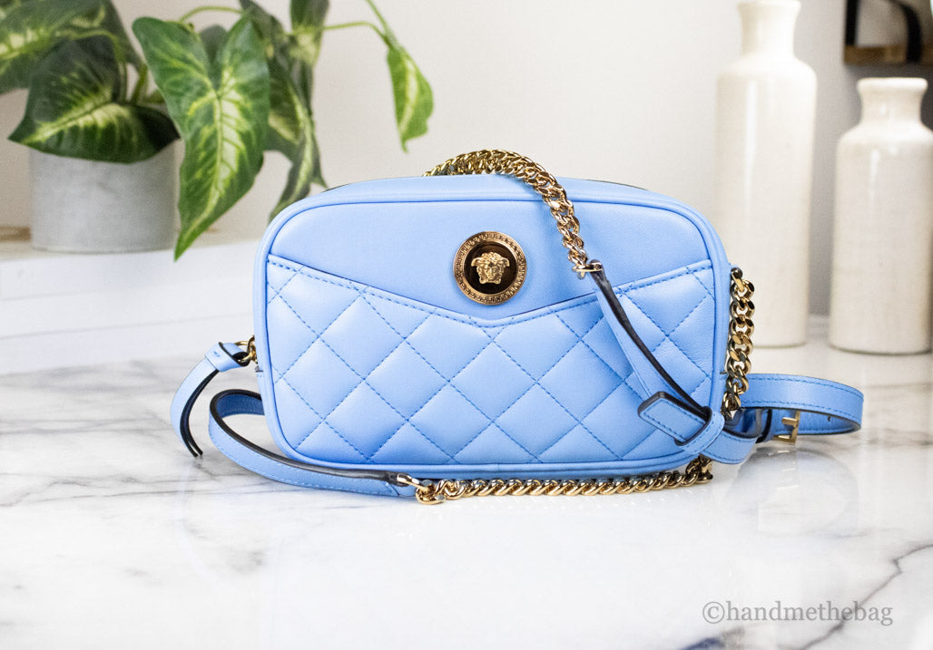 versace dv blue quilted crossbody on marble table