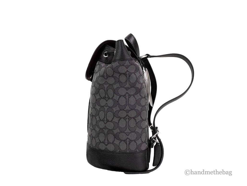 coach dempsey black smoke canvas backpack side on white background