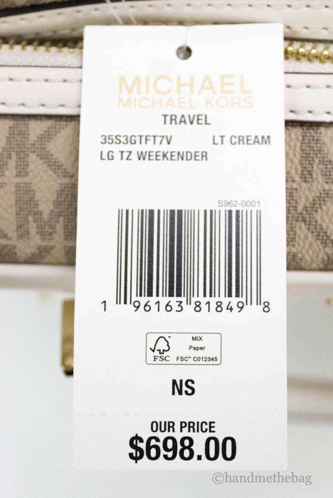 michael kors travle light cream duffle bag tag on white background