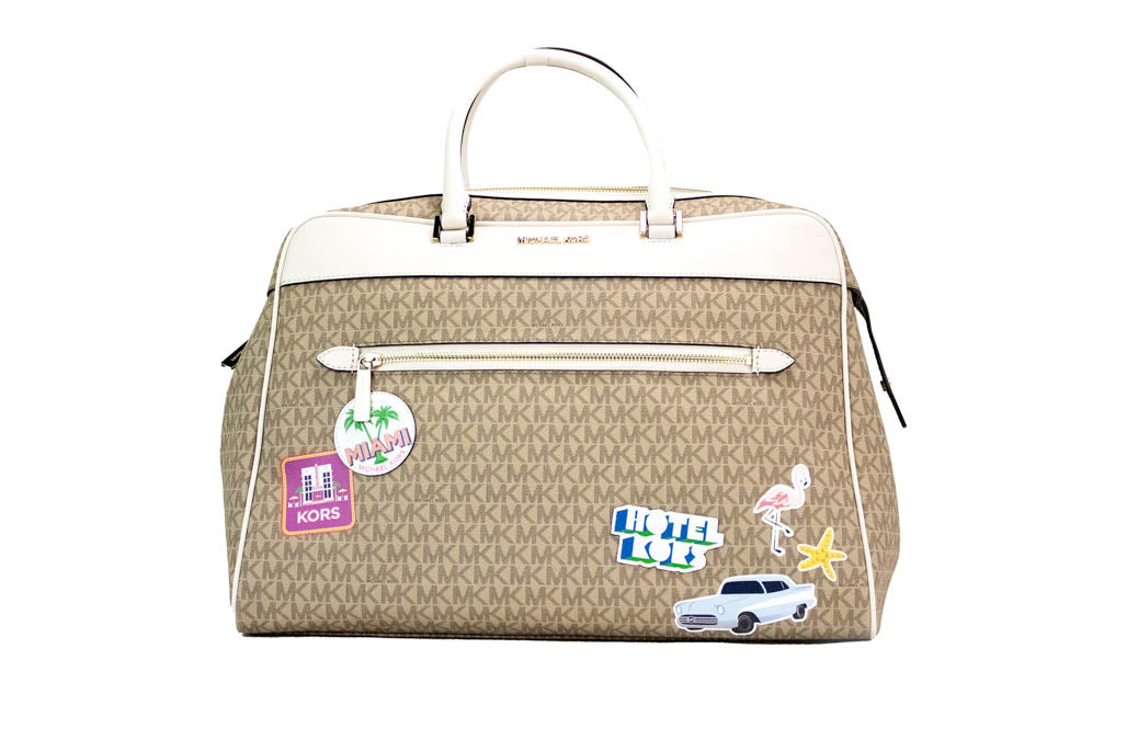 michael kors travel light cream patches duffle on white background