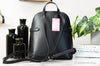 Kate Spade staci black dome backpack back on marble table