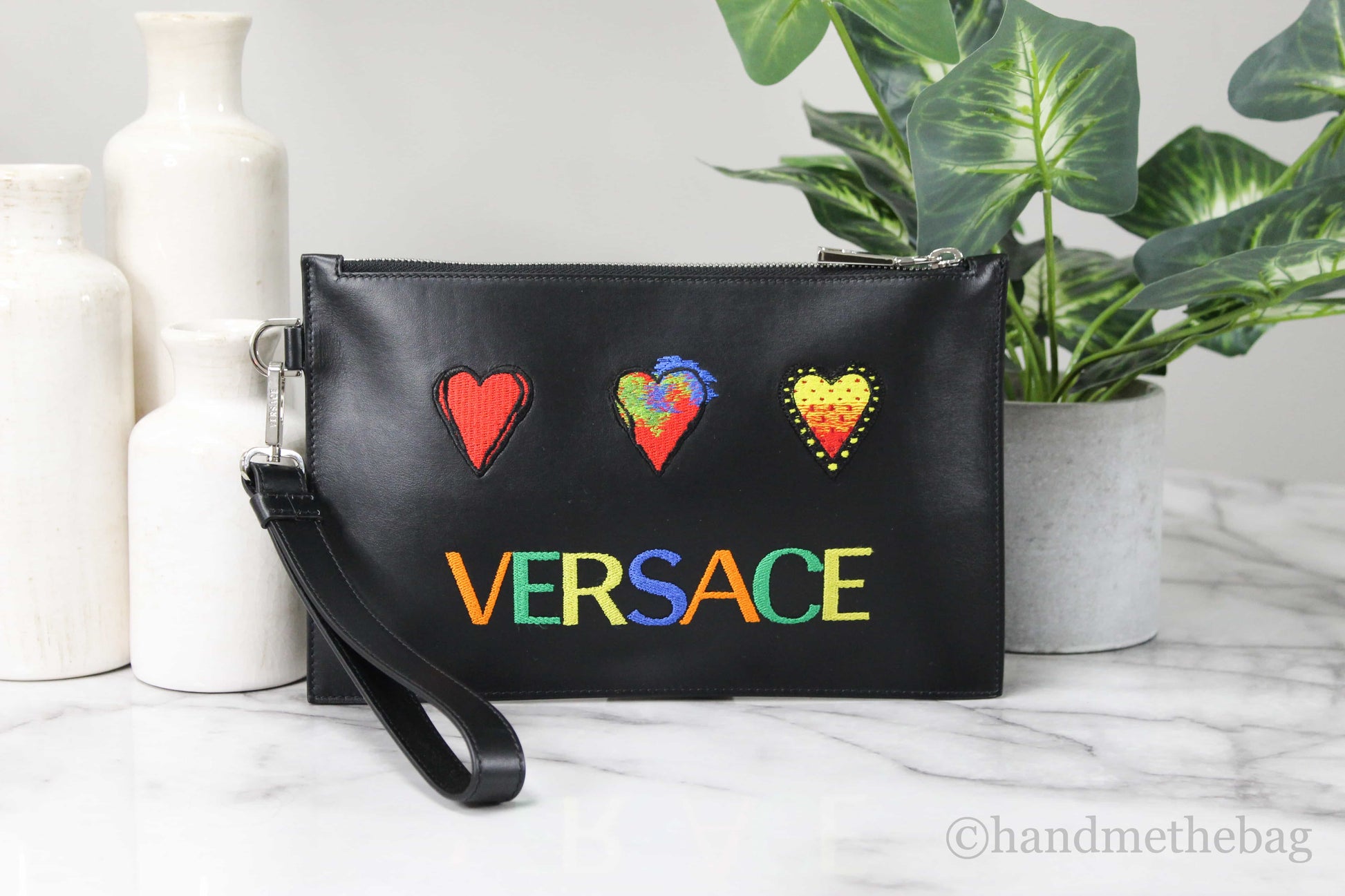 Versace heart patch pouch on marble table