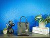 Michael Kors mercer black north south shopper bag against bright blue wall