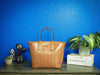 Michael Kors jodie luggage recycled tote against bright blue wall