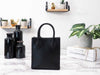 Michael Kors mercer black north south shopper bag back on marble table