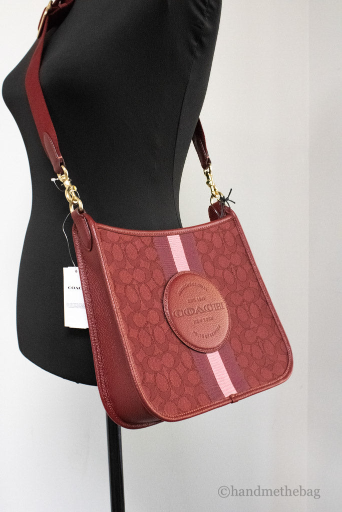 coach dempsey red apple file crossbody close up on mannequin