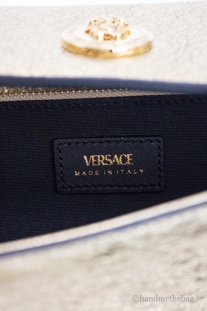 versace metallic gold evening bag inside on white background