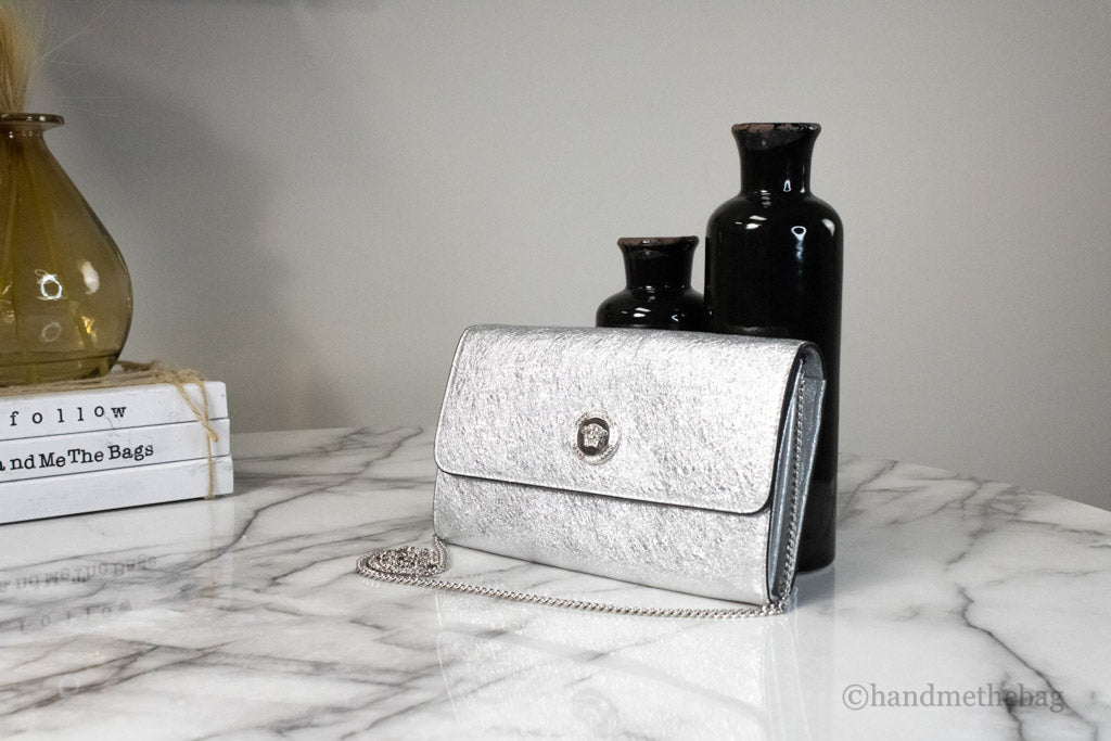 versace small metallic silver evening bag on marble table