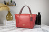 coach kacey colorblock red apple satchel on marble table