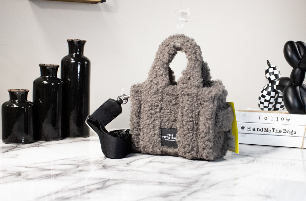 marc jacobs the teddy micro grey tote bag on marble table