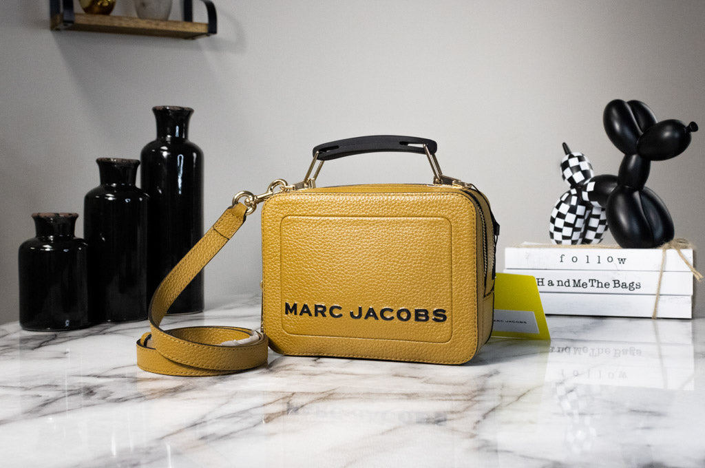 marc jacobs the box golden brown crossbody on marble table