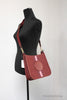 coach dempsey red apple file crossbody on mannequin