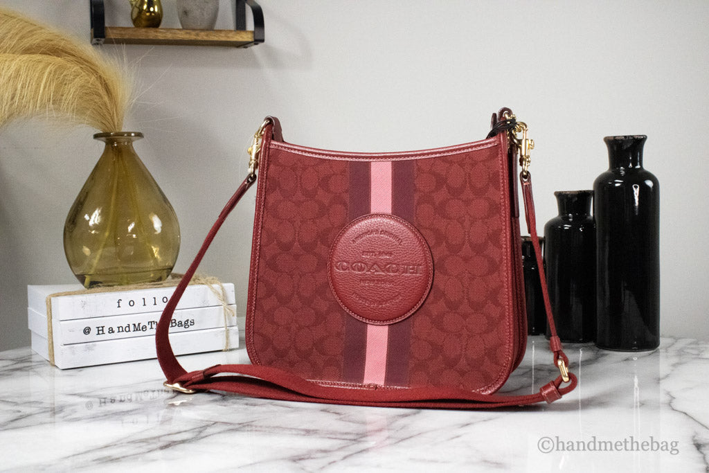 coach dempsey red apple file crossbody on marble table